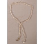A cultured pearl necklace, with a silver snake head clasp set with tourmalines, 32" long