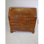 A George III mahogany fall front bureau with featherbanded inlaid decoration, the fall opening to