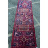 A Middle Eastern hand woven wool runner with geometric designs and stylised deer, 36" x 117"