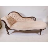 A Victorian walnut chaise longue, with a scrolled back and carved and pierced decoration, on