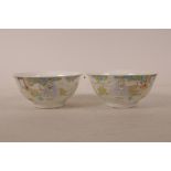 A pair of Chinese polychrome porcelain rice bowls decorated with figures taking tea in a