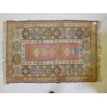 A Middle Eastern hand woven rug with geometric designs on a cream and pink ground, repairs, 36" x