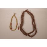 A string of Tibetan bone mala beads with metal vajra feature beads, together with a long string of