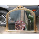 A contemporary gilt framed bevelled glass overmantle mirror with pierced and carved decoration,