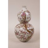 A Chinese polychrome porcelain double gourd vase decorated with birds perched on a tree in