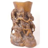 A Chinese carved wood brush pot/vase heavily carved with monkeys in a tree, 8½" high