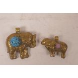 A brass pendant in the form of a ram set with a semi precious stone, and another in the form of an