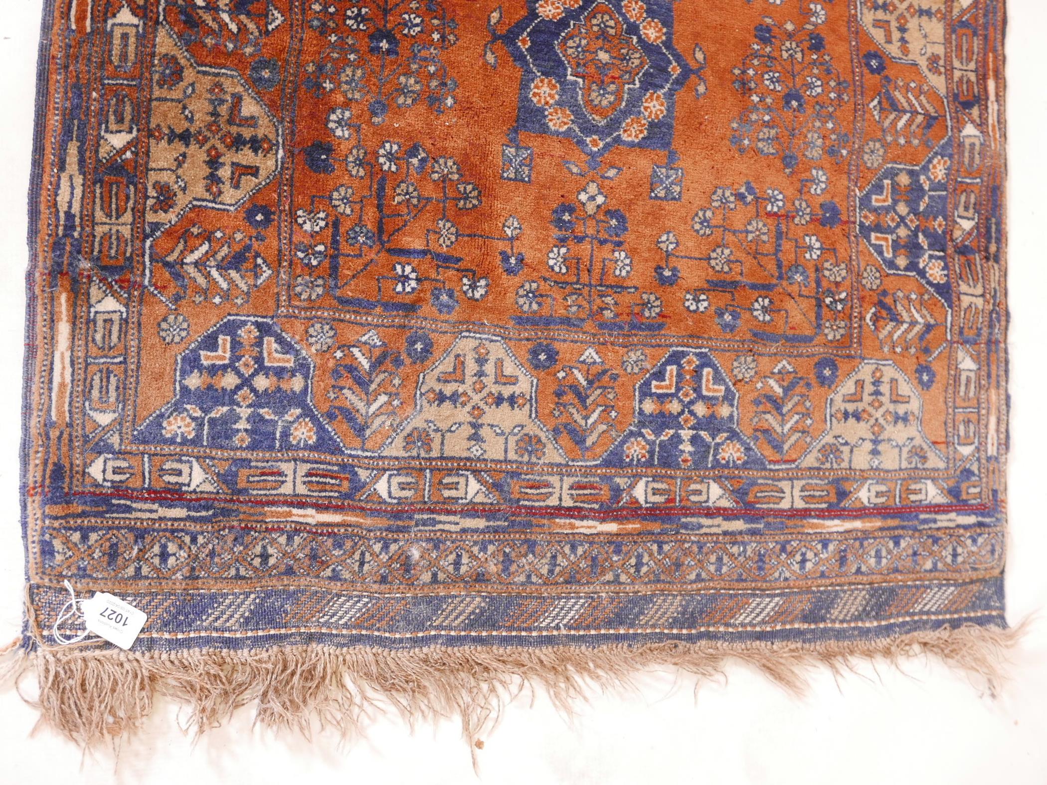 An Afghani wool rug with geometric patterns on a rust coloured field, 51" x 33" - Image 2 of 3