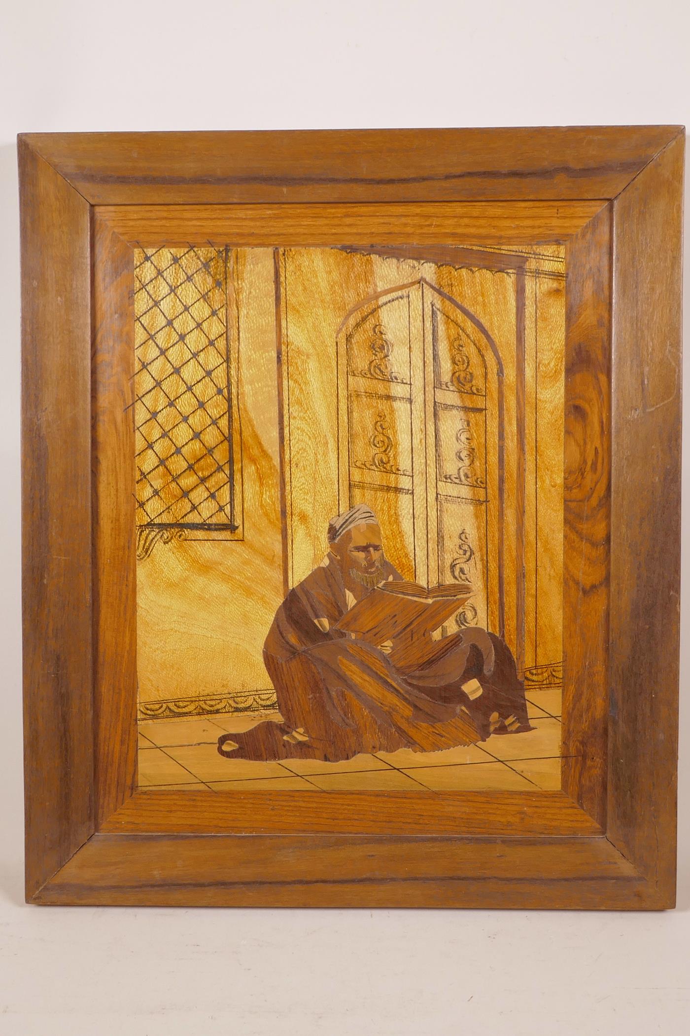 A marquetry inlaid panel depicting an Arab reading a book, 17" x 20"