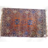 An Afghani wool rug with geometric patterns on a rust coloured field, 51" x 33"