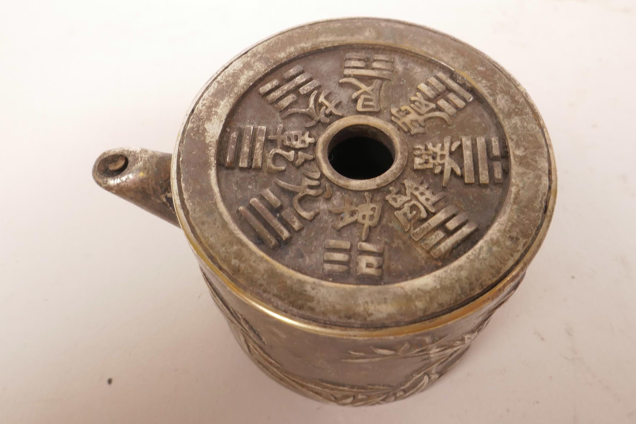 A small white metal tea pot with embossed oriental decoration and calligraphy, 1½" high x 2½" wide - Image 2 of 3