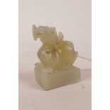 A Chinese celadon jade seal with carved dragon knop, 2" high
