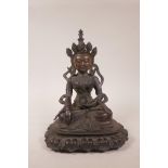 An antique Tibetan/Indian bronze figure of Shiva in chakra headdress seated upon a lotus throne,