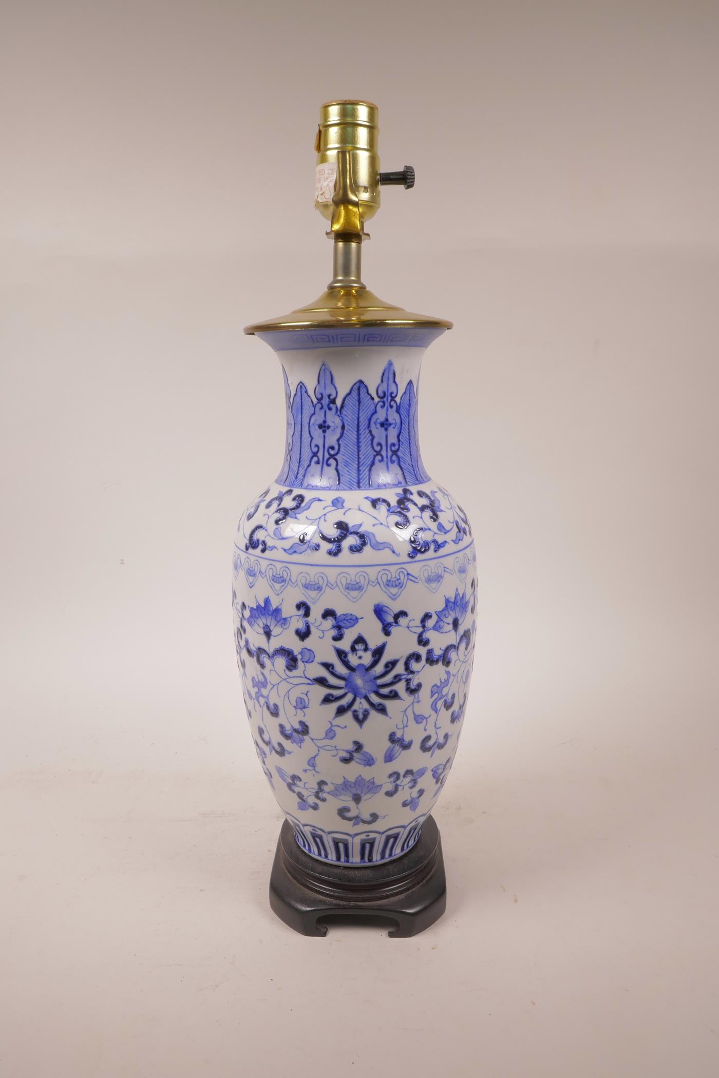 A Chinese blue and white porcelain vase with scrolling lotus flower decoration, converted to a lamp,