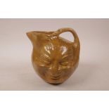 A composition Martinware style face jug, 7" high
