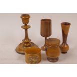 Five items of treen including a candlestick, Mauchlinware napkin ring, box and cover, etc