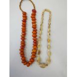 A string of reconstituted amber beads, 18" long, together with a horn bead necklace