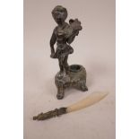 A bronze inkwell cast as a cherub playing a lyre, 6" high together with a mother of pearl paper