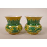 A pair of Chinese porcelain squat form vases, with green enamel phoenix and dragon decoration on a