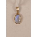 A yellow metal pendant set with a moonstone