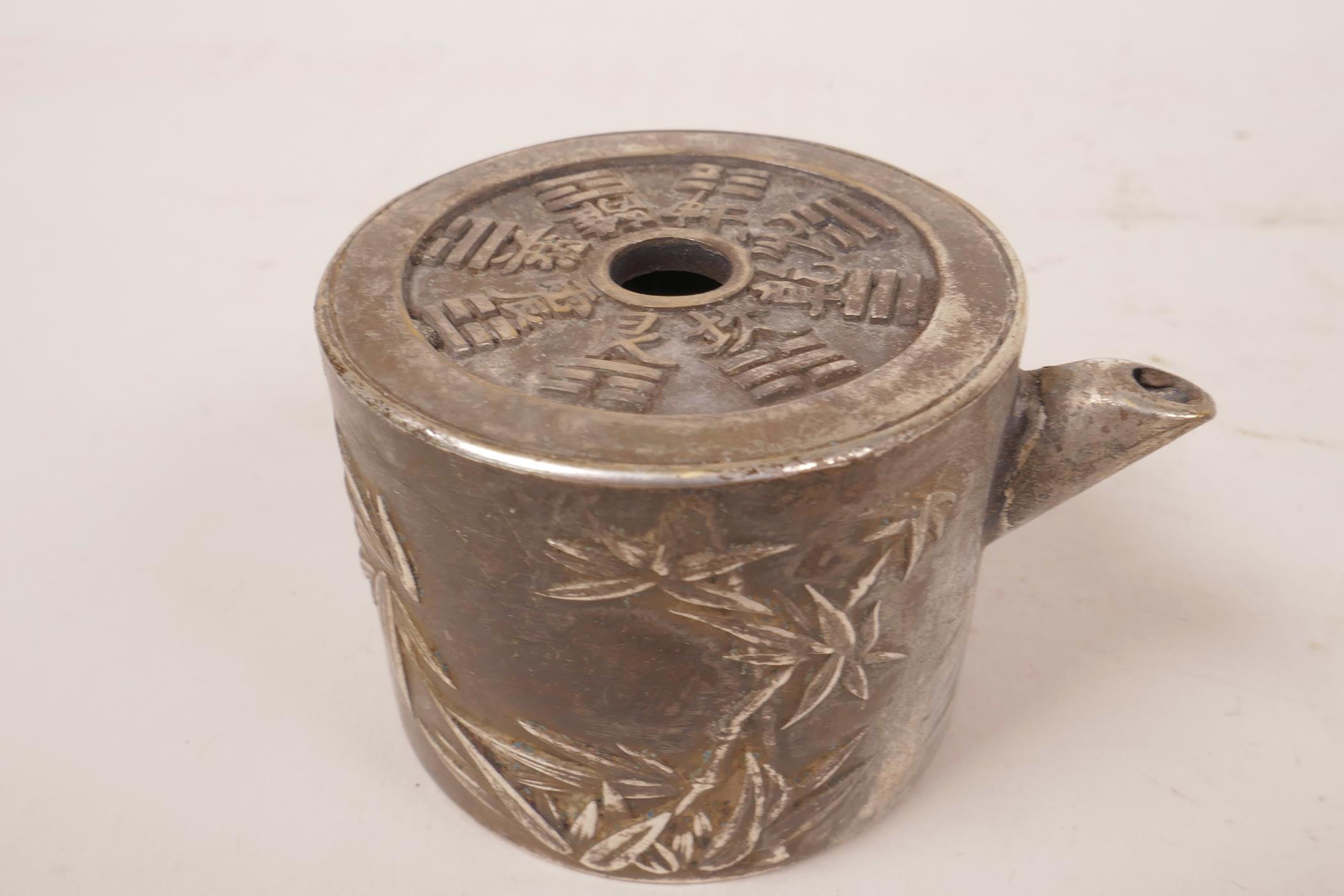 A small white metal tea pot with embossed oriental decoration and calligraphy, 1½" high x 2½" wide - Image 3 of 3