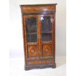 A late C19th French tulip wood display cabinet with brass mounts, the two doors over a single