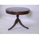 A C19th mahogany revolving drum table, with blind tooled leather top and four true and four dummy