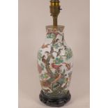 A C19th Chinese porcelain vase painted with exotic birds in bright enamels, reduced and fitted to