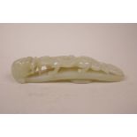 A Chinese green jade belt buckle with carved dragon decoration, 5½" long