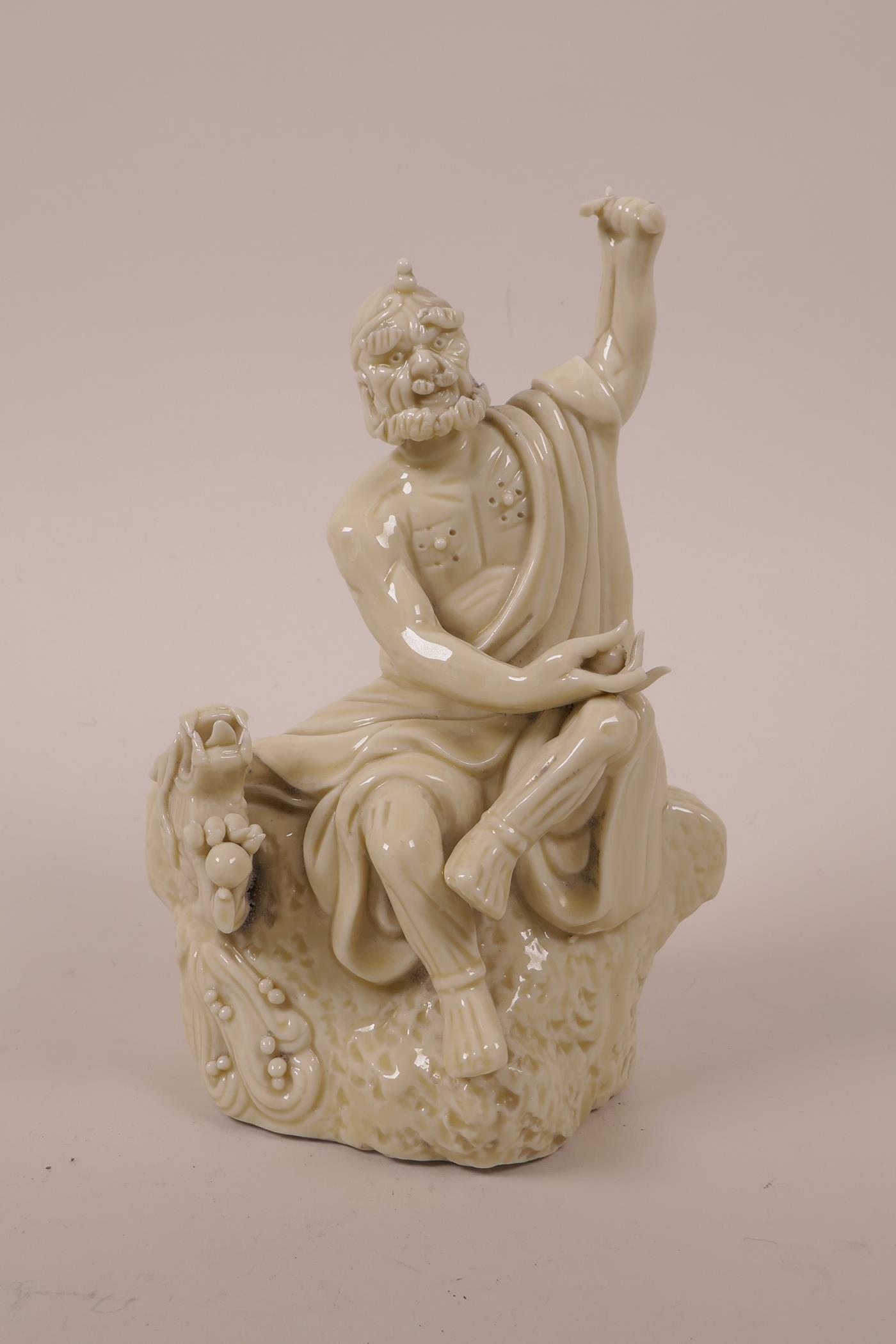 A Chinese blanc de chine porcelain Lohan seated on a rock with a dragon, impressed marks, A/F