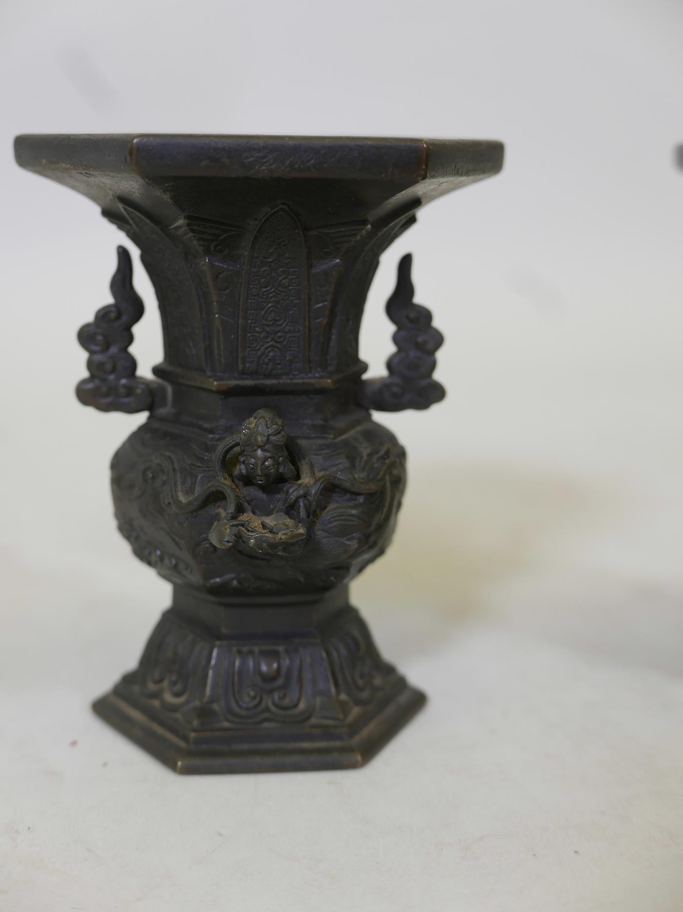 A pair of oriental bronze vases with raised decoration depicting deities flying amongst clouds, - Image 2 of 4