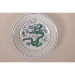 A Chinese blue and white porcelain bowl decorated with a green enamel dragon chasing the flaming