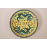 A Chinese yellow ground porcelain bowl decorated with a green enamel dragon chasing a gilt flaming