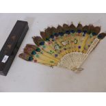 A C19th Cantonese fan of carved and pierced bone and peacock feathers, in original lacquered box