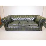 A green leather Chesterfield settee with studded decoration