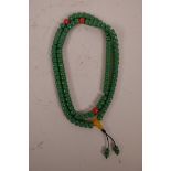 A string of green glass mala beads with coloured feature beads, 34" long