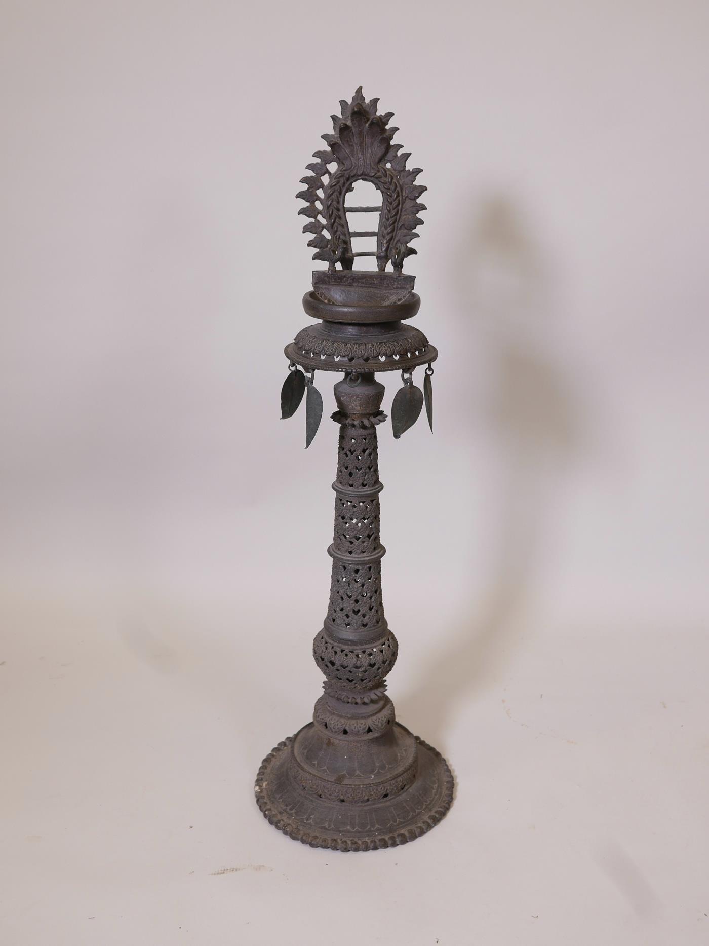 An Indian bronze standing lamp or stoop with pierced decoration to the column, 35" high x 10"