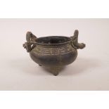 A Chinese bronze two handled censer on tripod supports, the handles in the form of dragons, six