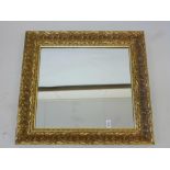 A wall mirror in floral embossed gilt frame (plate 18" x 21½")
