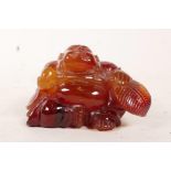 An agate carving of Budda, seated, and bearing a vessel and a branch, 2" high