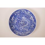 A Chinese blue and white porcelain charger decorated with dragons chasing the flaming pearl, six