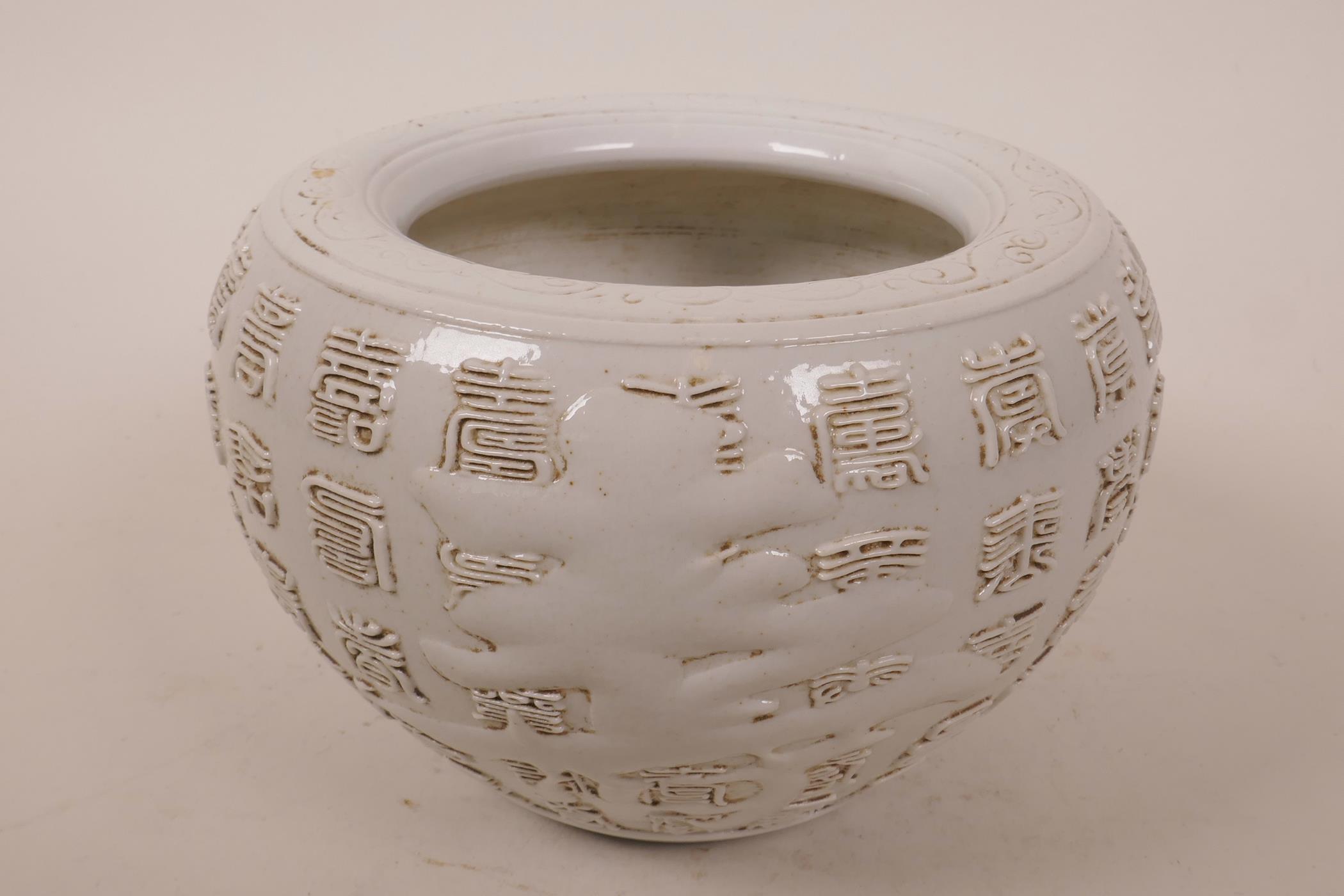 A Chinese jar with raised calligraphy on an off-white ground, marked to base, 6" diameter