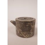 A small white metal tea pot with embossed oriental decoration and calligraphy, 1½" high x 2½" wide