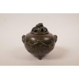 A Chinese bronzed metal censer and cover on tripod supports, with bat handles and raised bat