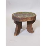 An African hardwood stool on tripod supports, with inset beaded decoration, 9" high x 9½" diameter