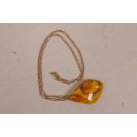 An amber pendant on 15ct gold chain, chain 5.5g