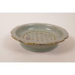 A Chinese celadon glazed porcelain dish with lobed rim, chased and gilt character inscription, 7½"