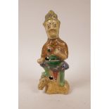 An Oriental earthenware figure of a deity standing on a horse, 11½" high