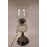 A C19th glass and brass oil lamp with glass shade and font on a classical brass and wood column