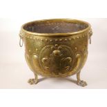 A late C18th/early C19th Dutch brass log bin with embossed floral and stud decoration, two lion's